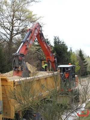 Sand wird in den Graben der Pflügemaschine einbebaut